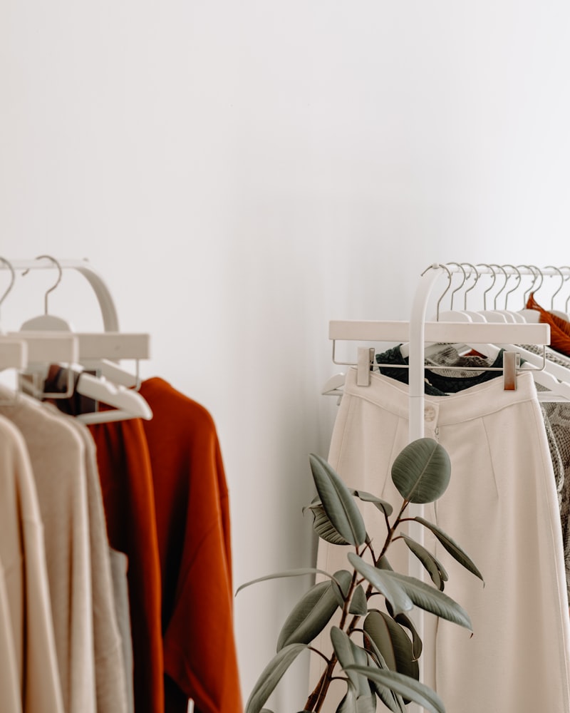 Portant de vêtements aux tons neutres dans la boutique.